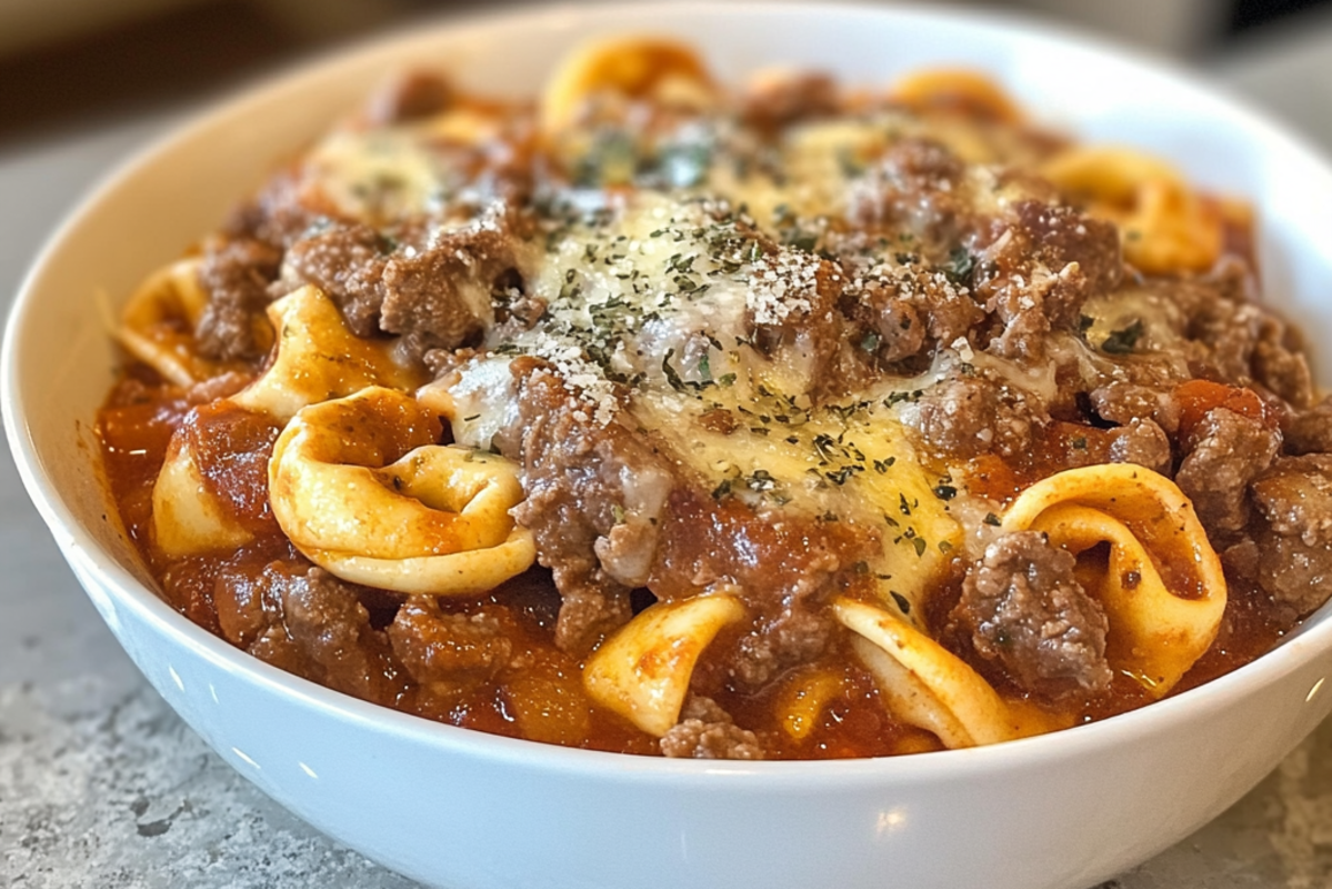 Cheesesteak Tortellini in a creamy provolone sauce garnished with fresh parsley in a white ceramic bowl.