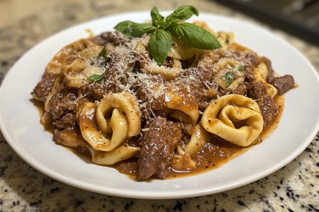 Philly Cheesesteak Tortellini with beef, vegetables, and creamy provolone sauce served in a white dish.